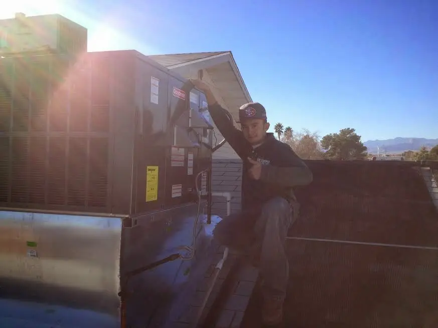 HVAC technician performing Heat Pump Repair on a rooftop unit in Carlisle