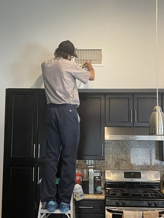 Technician inspecting an air vent during HVAC service in Carlisle